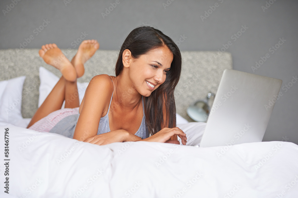 I love watching funny videos on my laptop. an attractive young woman watching a funny video online.