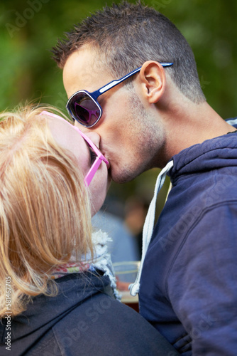 Lip locked lovers. an affectionate young couple sharing a kiss during a festival.