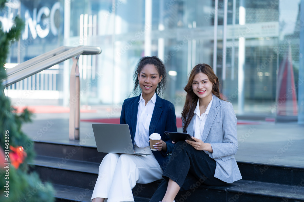 Two female employees working outdoors with laptops and tablets I want to give you an overview of this. Cropped image of two businesswoman using digital tablet to control work