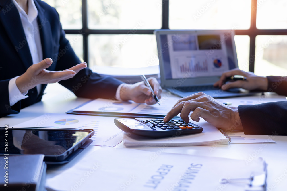 Obraz premium Group of confident business people point to graphs and charts to analyze market data, balance sheet, account, net profit to plan new sales strategies to increase production capacity. 