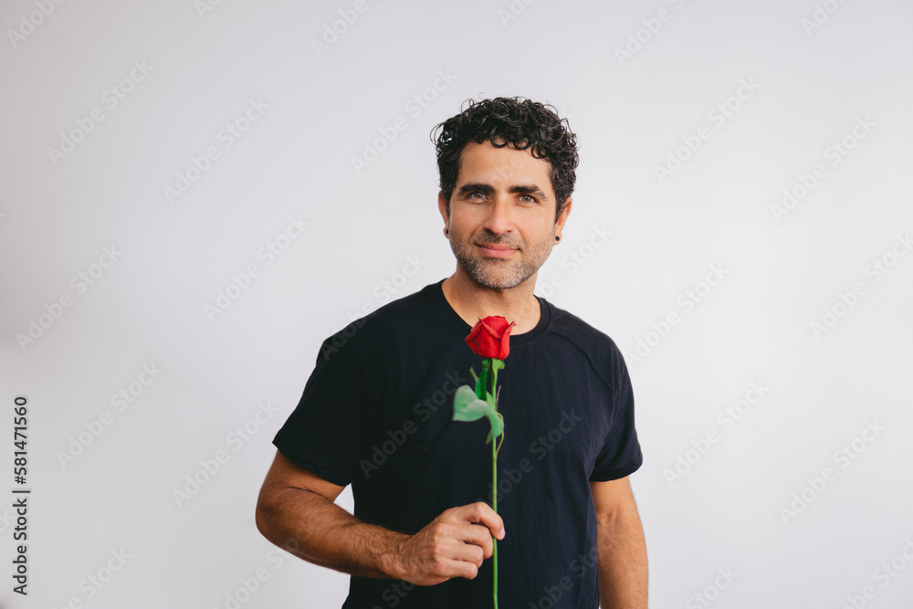 Middle-aged Latin man holding a rose while looking seductively at the camera on a white background. Middle-aged Latin man holding a rose while looking seductively at the camera on a white background.