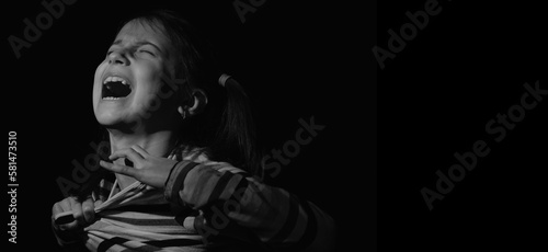 Loss childhood, mental health, depression, panic attacks and anxiety in children. Psychological portrait of nervous child girl screams for help. Horizontal black and white image.