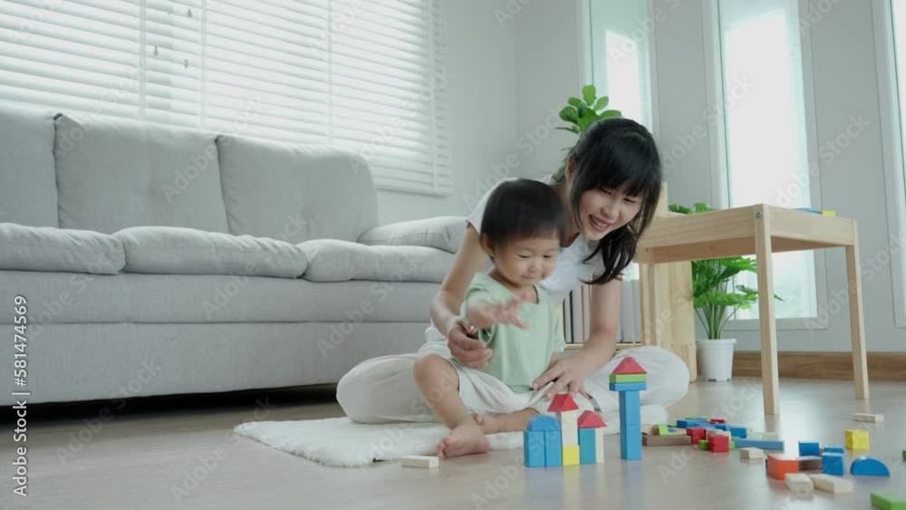 Happy Asia mother play and learn toy blocks with the little girl. Funny family is happy and excited in the house. Mother and daughter having fun spending time together. Holiday, Activity, development Happy Asia mother play and learn toy blocks with the little girl. Funny family is happy and excited in the house. Mother and daughter having fun spending time together. Holiday, Activity, development