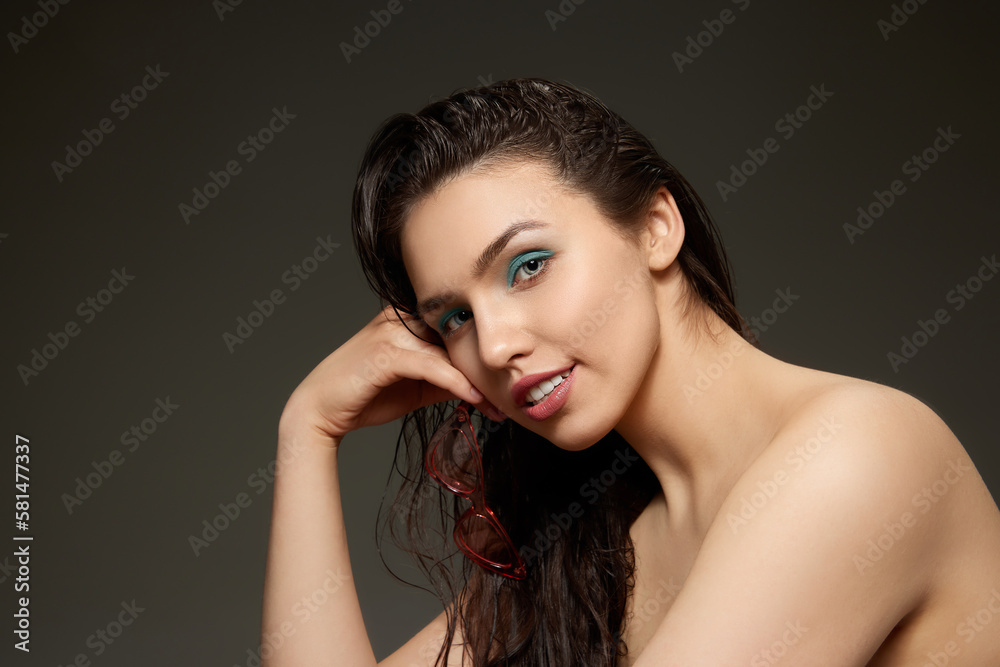 Obraz premium Half-length portrait of young emotional beautiful girl looking at camera isolated over grey background. Beauty, fashion, style, fun and joy concept