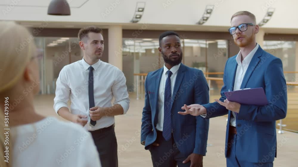 Diverse colleagues discuss business strategy in office hall. Diverse colleagues discuss business strategy in office hall.