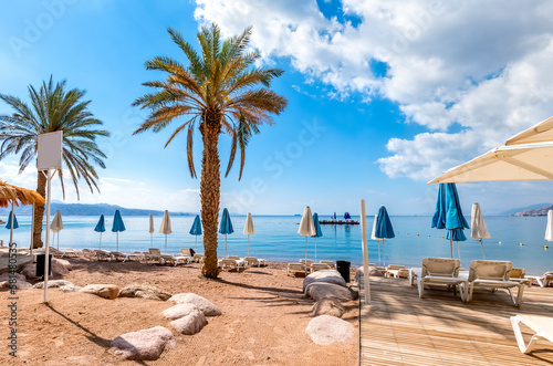 Fototapeta Naklejka Na Ścianę i Meble -  Morning on central public beach of the Red Sea in Eilat - famous tourist resort and recreational city in Israel. Concept of bliss vacation and happy holiday  

