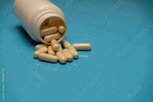 Bote abierto con cápsulas medicamentosas photo