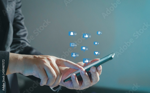 Social media interactions on mobile phone  concept with notification icons of like  message  email  comment and star above smartphone screen  person hands holding device  internet digital marketing