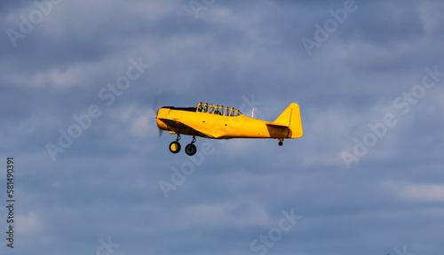 Small old plane in the air. Blue sky background.