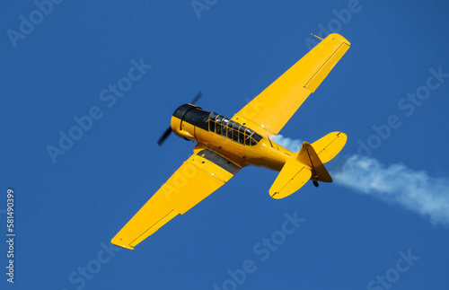 Small old plane in the air. Blue sky background.