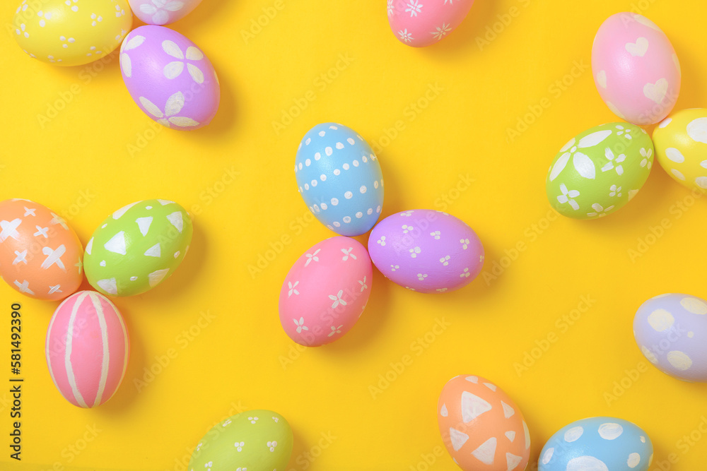 Happy easter holiday celebration concept. Group of painted colourful eggs decoration on a yellow background. Seasonal religion tradition design. Top view, flat lay, copy space.
