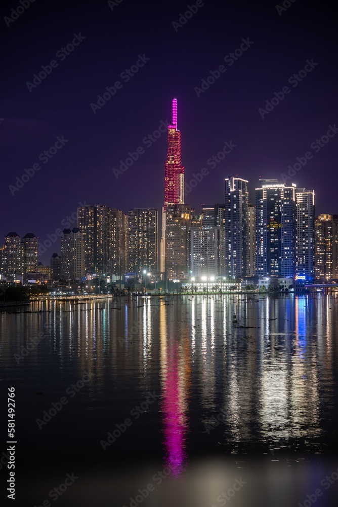 Fototapeta premium Illuminated skyscrapers near river at night