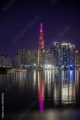 Illuminated skyscrapers near river at night © MariaEugenia