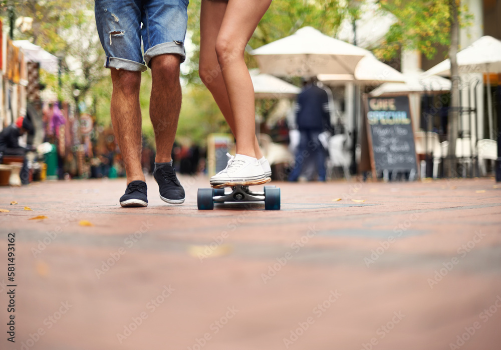 Taking it one ride at a time...a young couples legs with one balancing on a skateboard,. Taking it one ride at a time...a young couples legs with one balancing on a skateboard,.