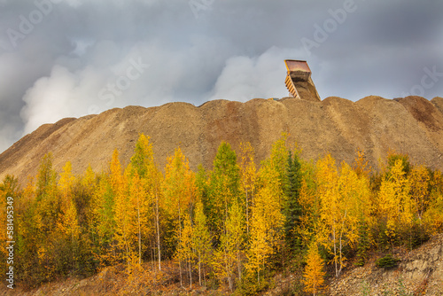 Gold mining in Canada's Yukon Territory; heavy truck is unloading on a dump with mine tailings photo