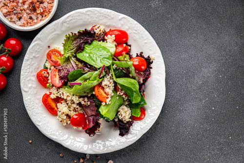 quinoa salad tomato, green lettuce mix healthy meal food snack on the table copy space food background rustic top view keto or paleo diet veggie vegan or vegetarian food