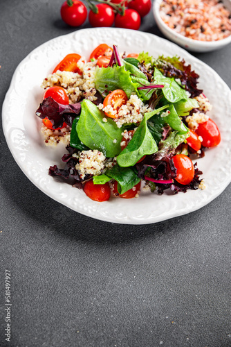 quinoa salad tomato, green lettuce mix healthy meal food snack on the table copy space food background rustic top view keto or paleo diet veggie vegan or vegetarian food