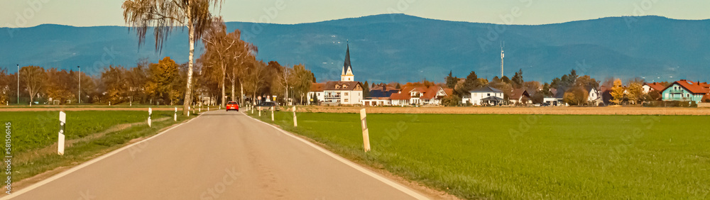 Autumn or indian summer view with a church and the Bavarian forest in the background near Strasskirchen, Bavaria, Germany