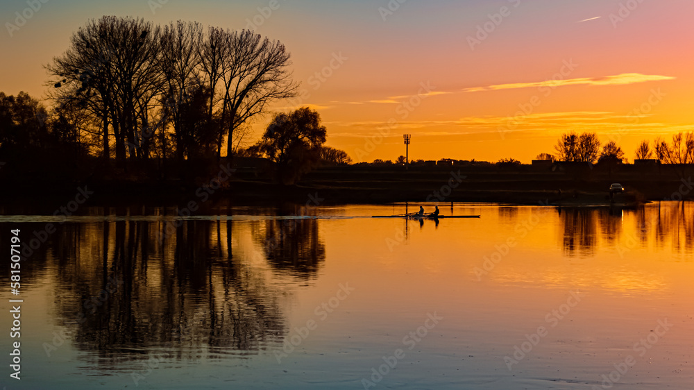 Sunset with reflections and rowers near Metten, Danube, Bavaria, Germany