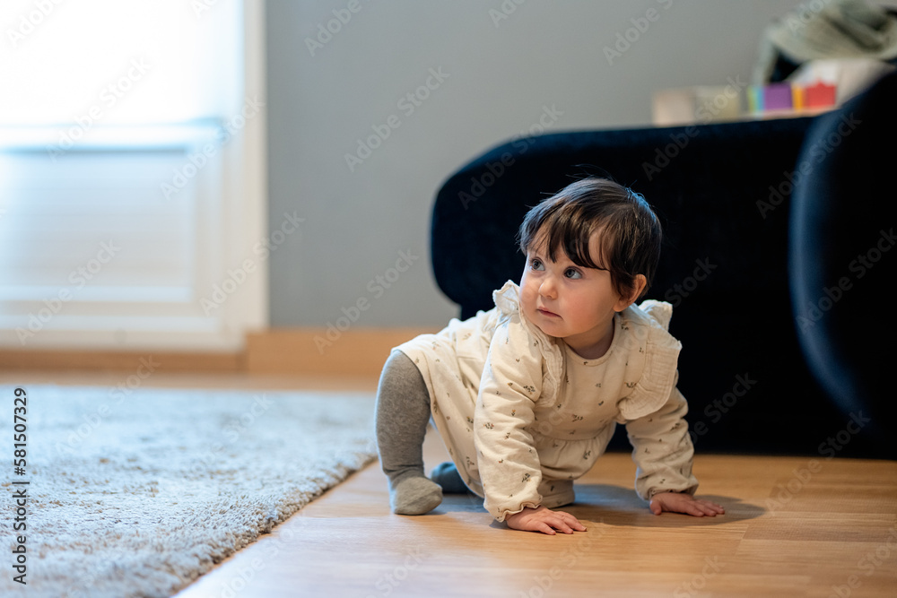 Cute little girl crawling on floor and looking away Cute little girl crawling on floor and looking away