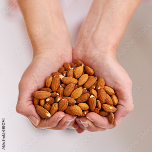 The nutty health solution. a bunch of almonds in a persons cupped hands.