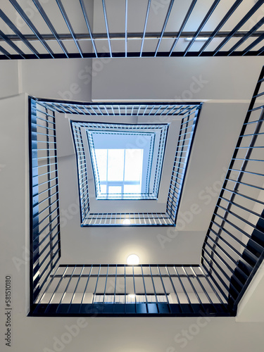 Bottom-up view of rectangular spiral staircase in modern multi-storey residential and office building © A2LE