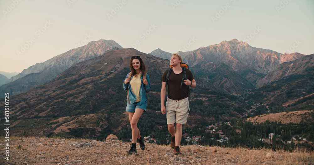 Young couple having an adventure, exploring beautiful mountains, hiking with backpacks, having an active vacation - active lifestyle, freedom concept 