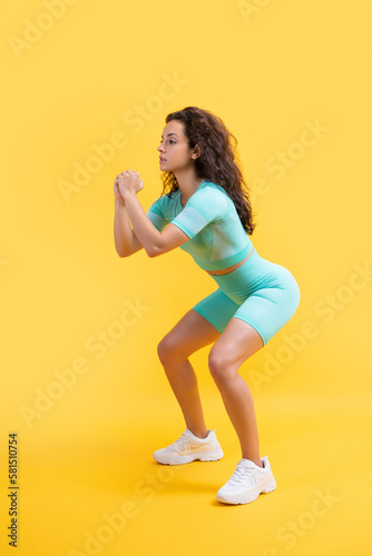 fitness sportswoman squatting in sportswear at studio. fitness sportswoman in sportswear squatting