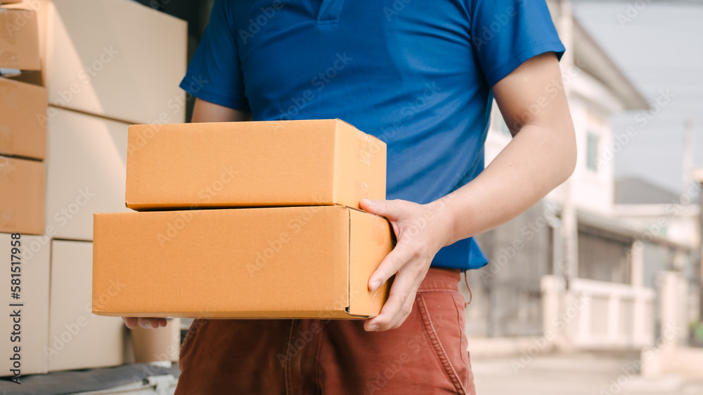 Close up logistic worker delivering cardboard boxes to recipient at home door. Close up logistic worker delivering cardboard boxes to recipient at home door.