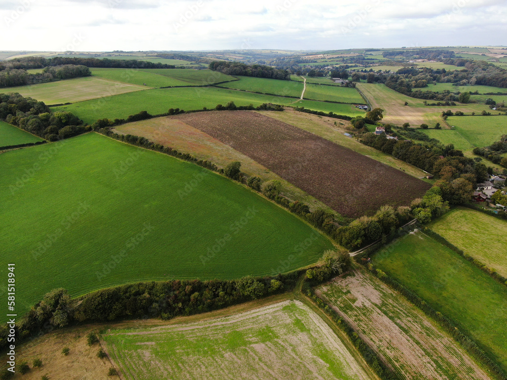 An aerial view of some large ploughed fields and a country road in Dorset, England