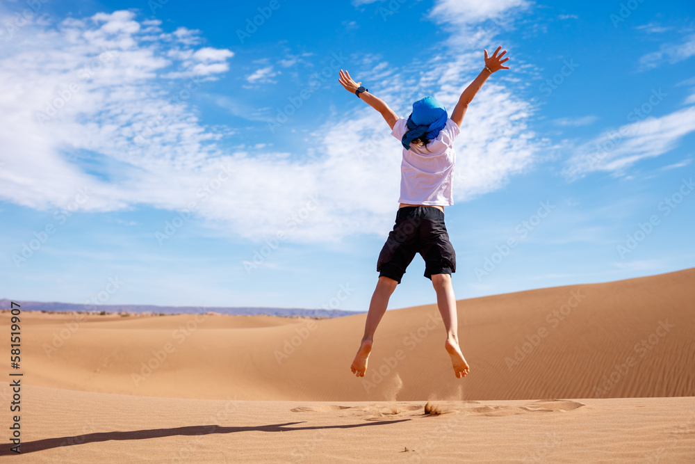 Children jumping in sand dunes in the Sahara desert Stock Photo Adobe