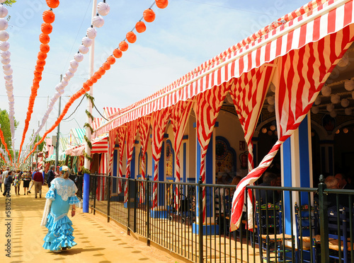 Mujer con traje de gitana paseando por el real de la feria. Feria de Abril, Feria de Sevilla, Fiestas en España. 