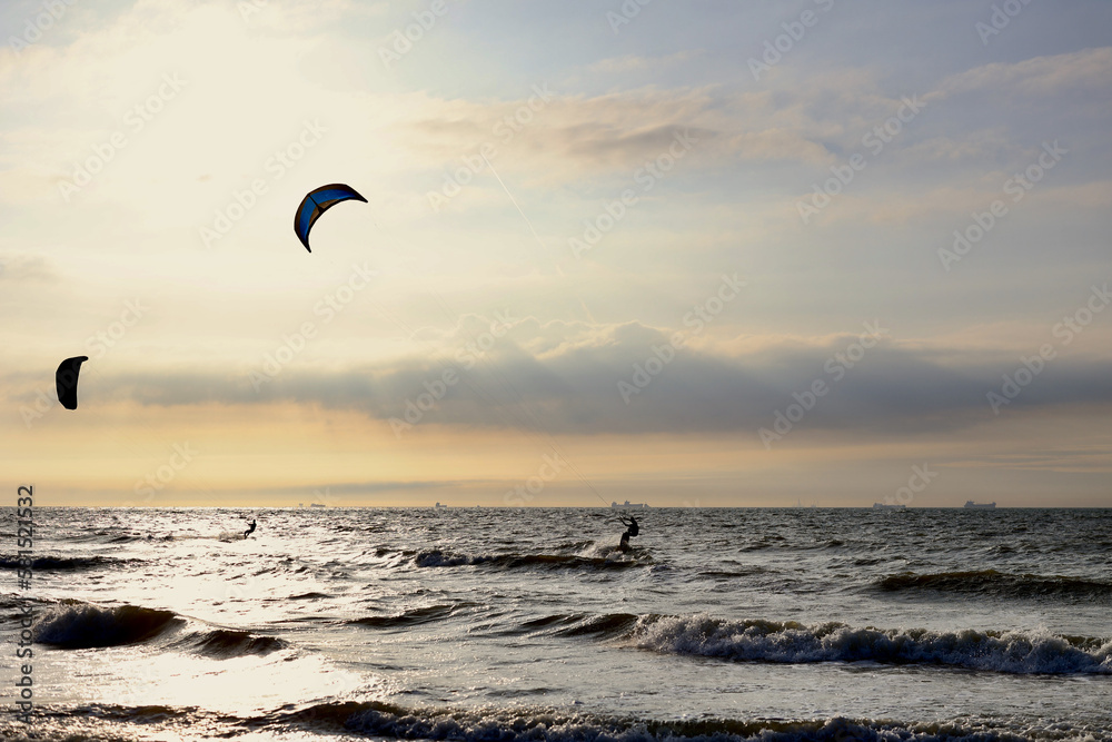 Kitesurfing in the evening at a Dutch beach on a windy spring day. The north sea near Wassenaar, The Netherlands. Kitesurfing in the evening at a Dutch beach on a windy spring day. The north sea near Wassenaar, The Netherlands.