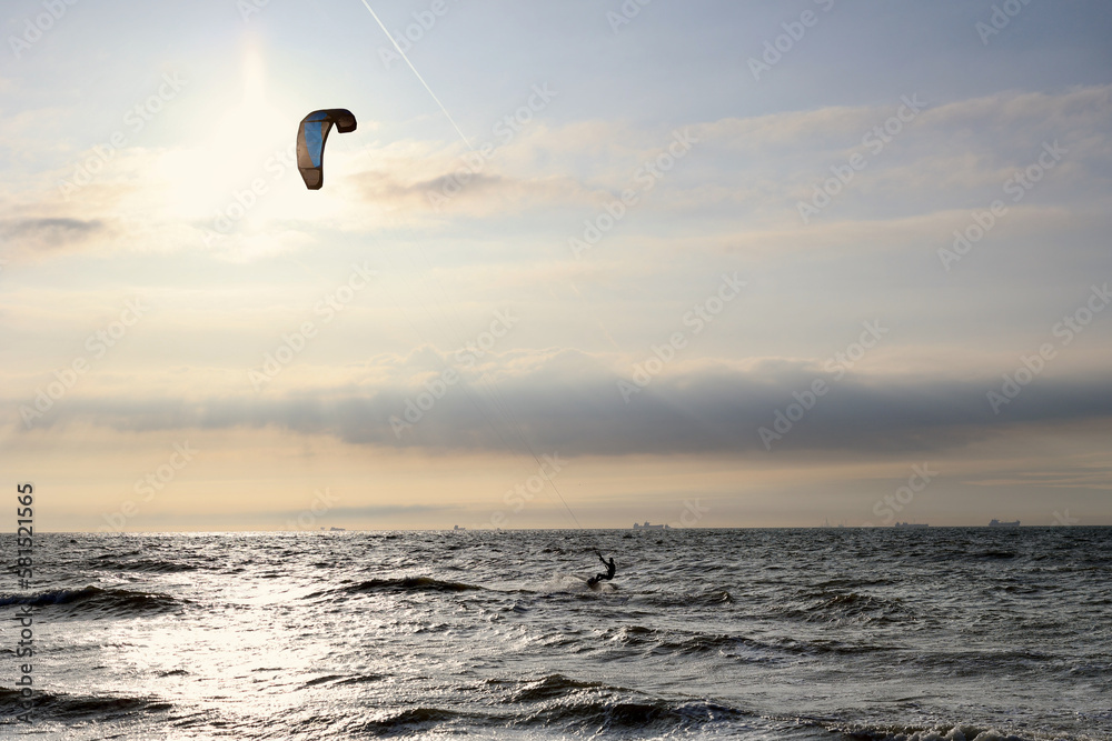 Kitesurfing in the evening at a Dutch beach on a windy spring day. The north sea near Wassenaar, The Netherlands. Kitesurfing in the evening at a Dutch beach on a windy spring day. The north sea near Wassenaar, The Netherlands.
