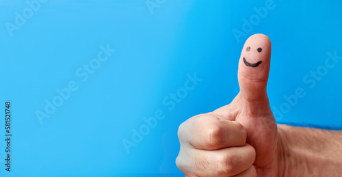 A man folded his fingers and raised a thumbs up with an emoticon image.