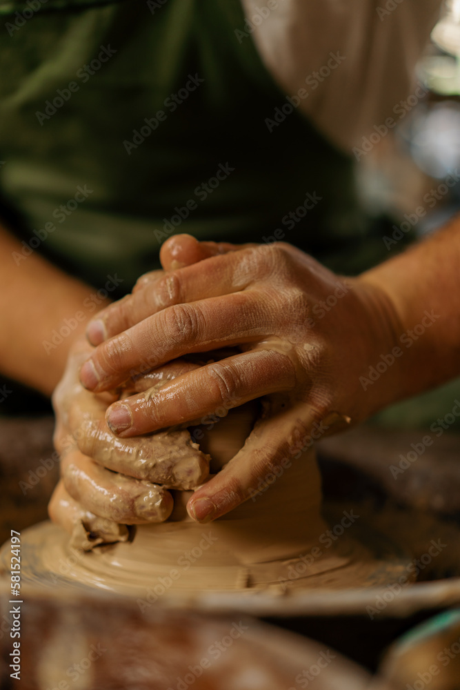 Pottery workshop Potter working with clay on the potter's wheel potter's tools hands in clay