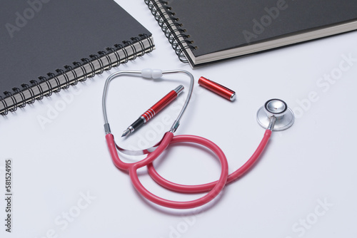 Stetoskop medyczny na białym tle obok notatników 