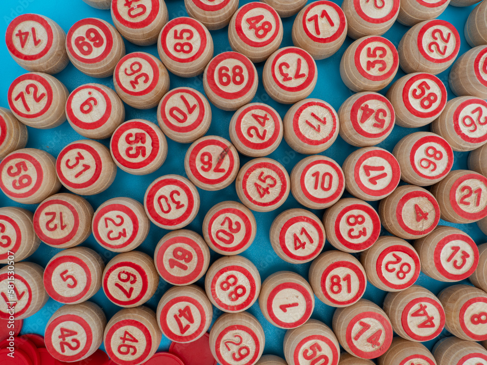 Board game bingo. Wooden barrels with lotto numbers, playing cards for the game. Close-up. Board game bingo. Wooden barrels with lotto numbers, playing cards for the game. Close-up.