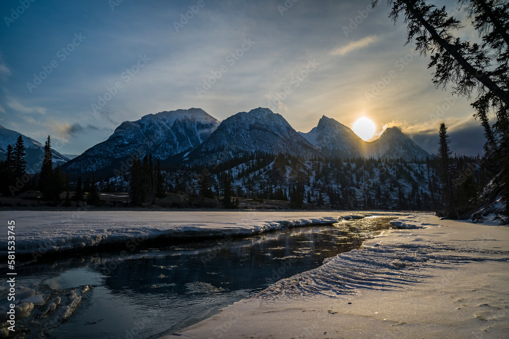 frozen siffleur mountain river during sunrise with refelction and pieces of ice in water