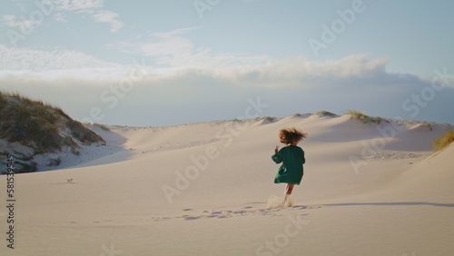 Brunette artist dancing sand dunes at summer. Woman moving actively at desert.
