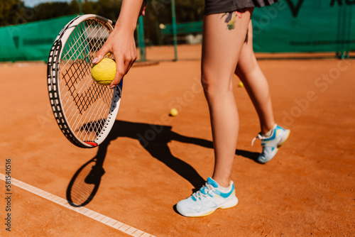 Caucasian european woman hold yellow green ball, playing tennis match on clay court surface on weekend free time sunny day. Female player ready to serve. Professional sport concept 