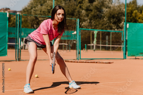 Caucasian european woman hold yellow green ball, playing tennis match on clay court surface on weekend free time sunny day. Female player ready to serve. Professional sport concept   © Volodymyr