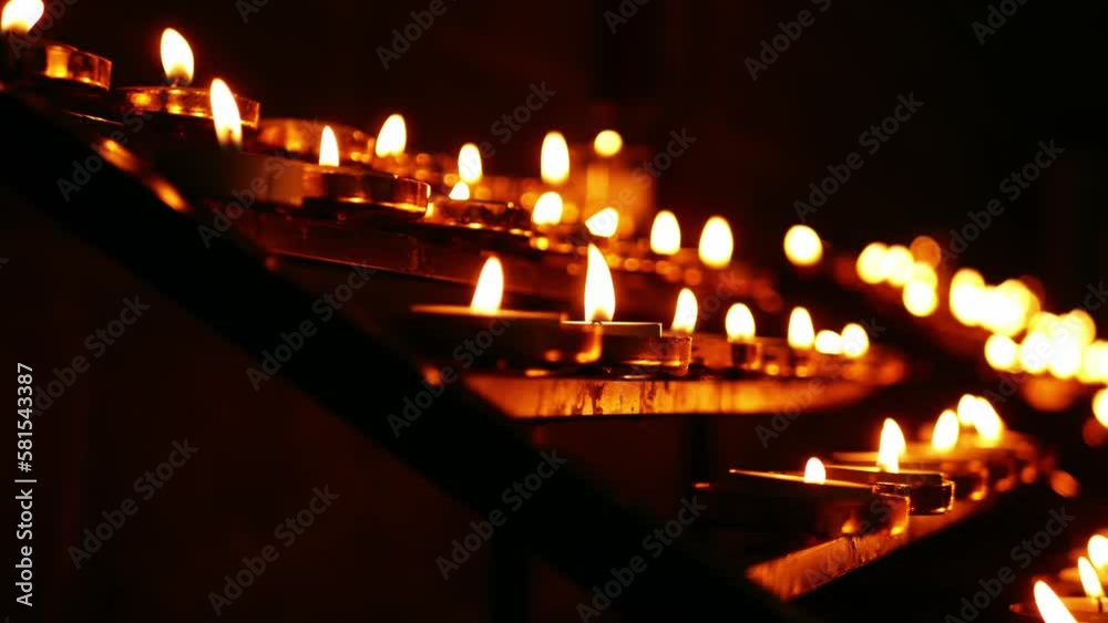 Rows of tea light candles bokeh defocussed burning in a church Rows of tea light candles bokeh defocussed burning in a church