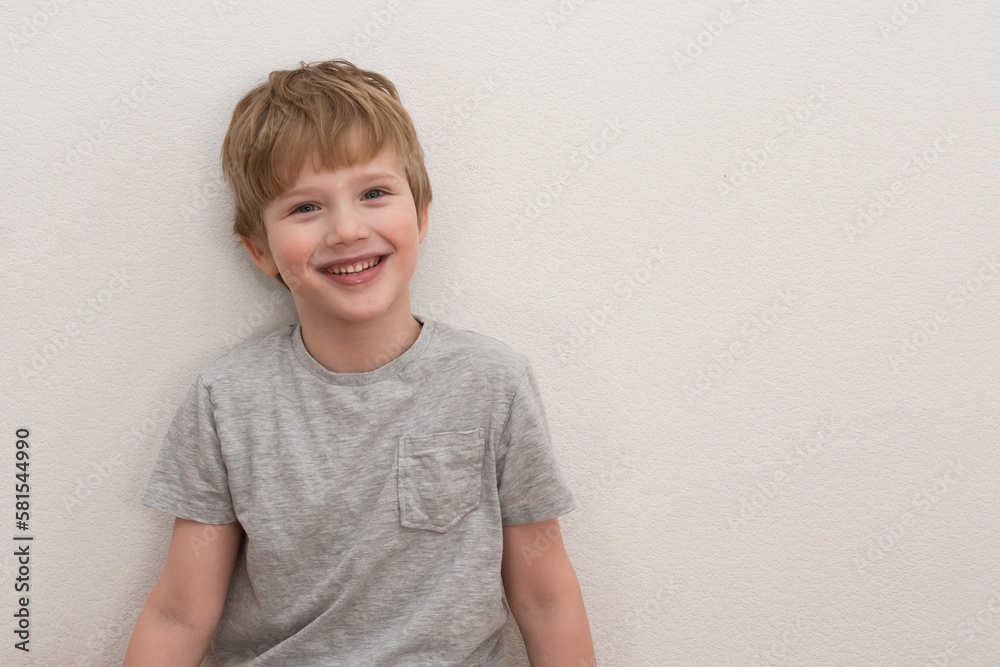 Portrait of happy adorable european boy in casual outfit over white background.Cute blond hair boy in grey T-shirt. Portrait of happy adorable european boy in casual outfit over white background.Cute blond hair boy in grey T-shirt.