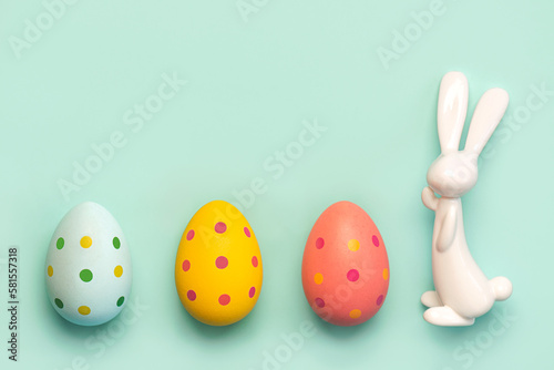 Happy Easter. Close-up of three easter eggs next to easter bunny with copy space for text