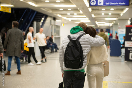 Young couple hugging and walking through the airport terminal