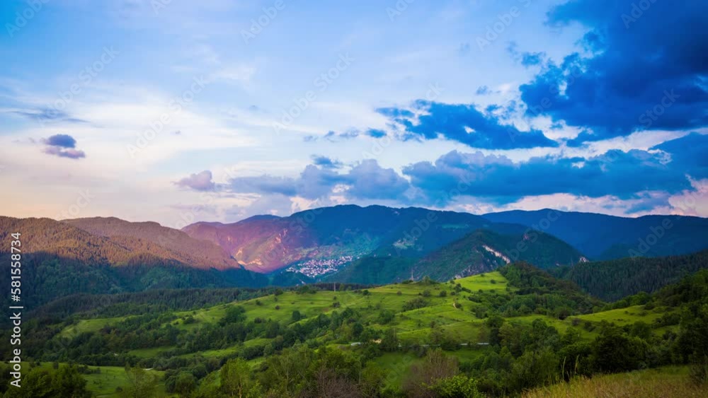 Multicolored sky with clouds and sunset light over the Rhodope Mountains with a intermountain village Multicolored sky with clouds and sunset light over the Rhodope Mountains with a intermountain village