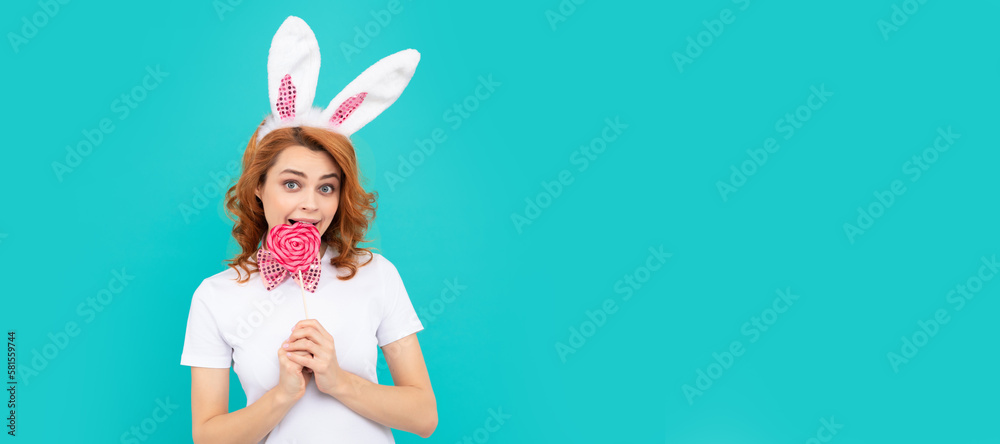 happy easter girl wear bunny ears hold yummy lollipop. Woman isolated face portrait, banner with mock up copyspace. happy easter girl wear bunny ears hold yummy lollipop. Woman isolated face portrait, banner with mock up copyspace.