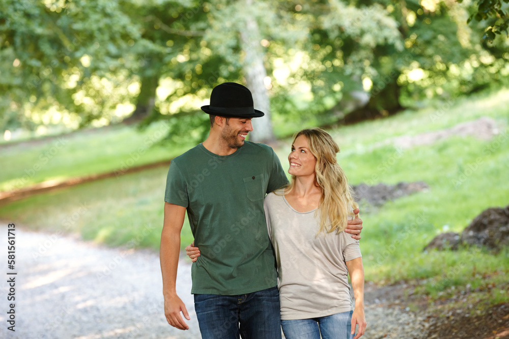 Fototapeta premium Loving every minute together. a young couple walking arm in arm in a park.