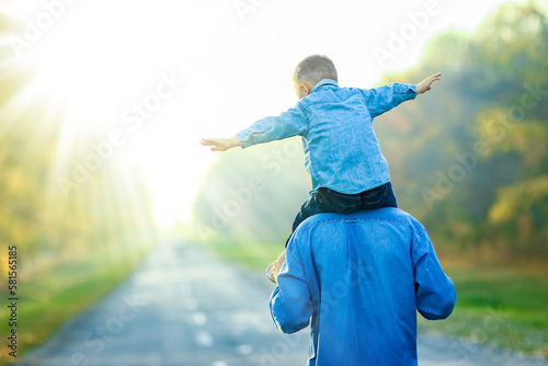 A Happy parent with child are walking along the road in the park on nature travel